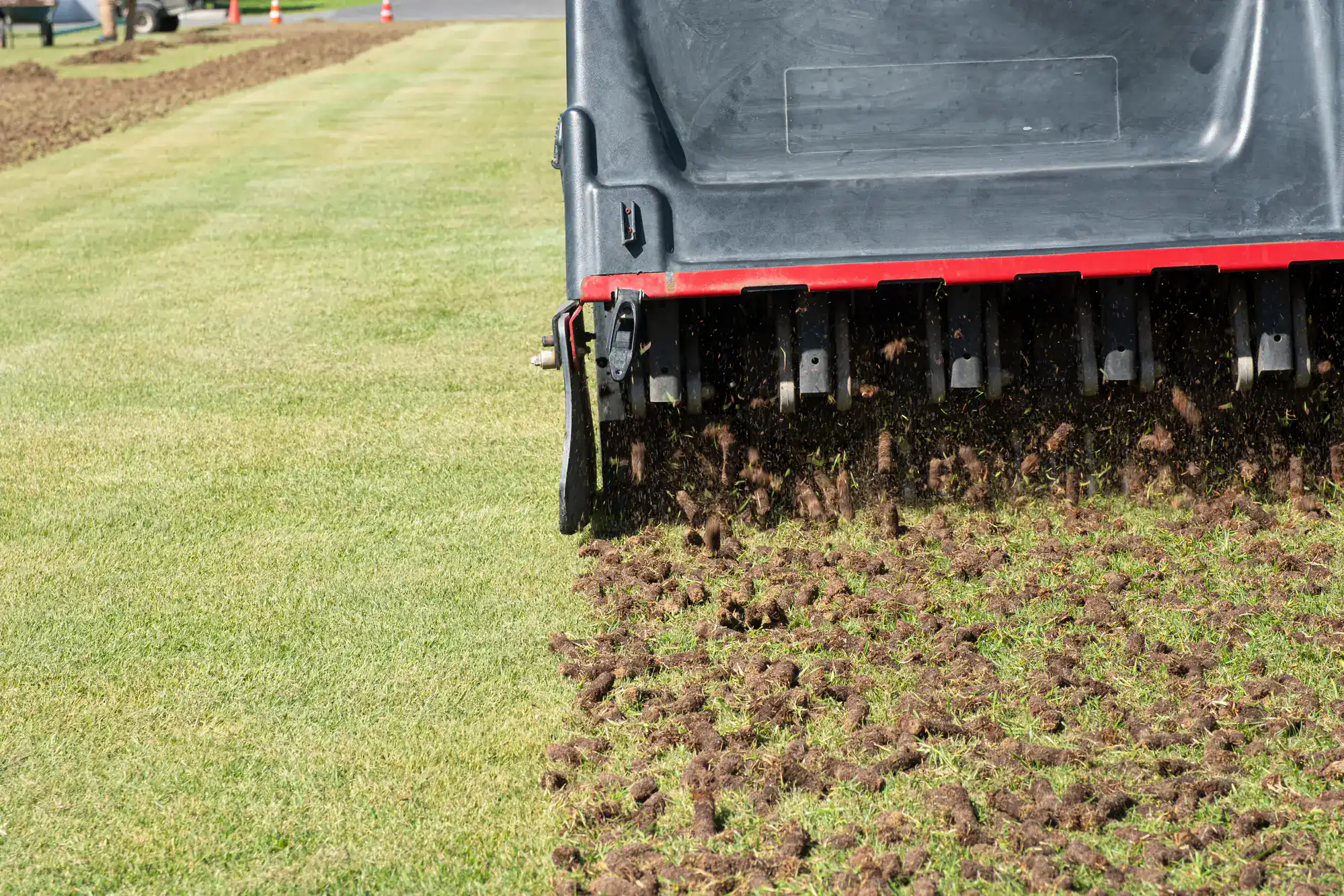 A lawn aerator machine works on grass, leaving plugs and holes perfect for Lawn Renovation Suffolk County.